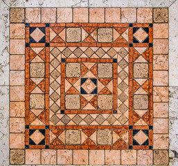 Marble mosaic of different colors on the wall in close-up.