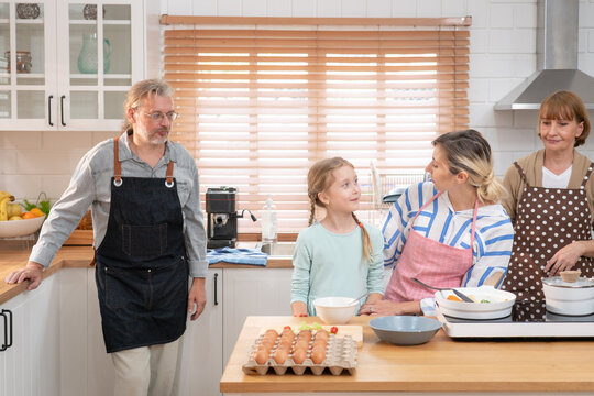 Happy big family prepare cooking for food in kitchen at home. Senior elderly grandparent and their daughter having fun spend leisure time together, making breakfast with happiness in house.