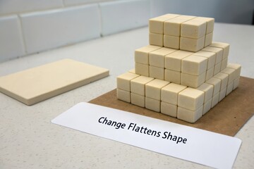 Stacked cubes dissolving into a single flat tile