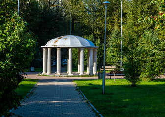 Stone gazebo with columns in the park in summer.