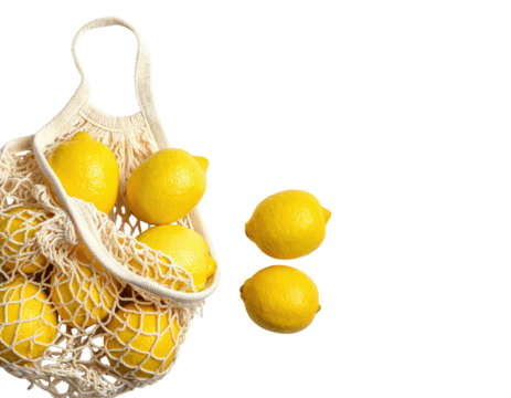 Bright yellow lemons spilling out of a mesh bag and scattered on a solid black background