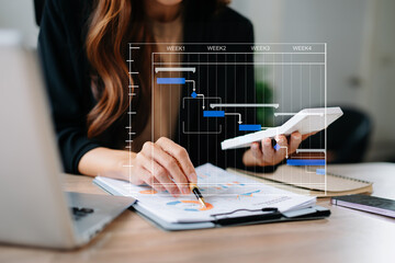 Project manager working and update tasks with milestones progress planning and Gantt chart scheduling diagram. business working with smart phone, tablet and laptop in office.