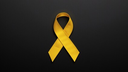 A solitary golden awareness ribbon stands out against a stark black background symbolizing hope and support