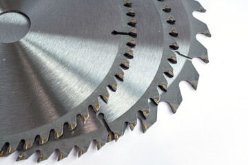 Three stacked circular saw blades with tungsten carbide-tipped teeth, showcasing heavy-duty cutting tools, industrial precision, and layered metal texture for manufacturing, construction, and power to