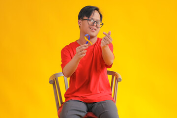 Happy Young Man Supports Down Syndrome Awareness With Ribbon on Vibrant Yellow Background