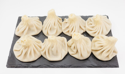 Steamed Georgian Khinkali On Black Slate Platter. Fresh Handcrafted Dumplings For Sharing