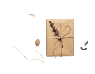 A wrapped gift tied with twine and adorned with eucalyptus sprigs against a stark black background