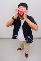 Man standing and eating up the whole bowl of dish covering his face