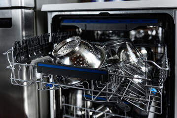 An open dishwasher with clean dishes in the kitchen.
