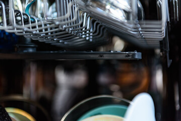 An open dishwasher with clean dishes in the kitchen.
