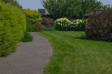 Path winding through landscaped garden featuring lush greenery and flowers