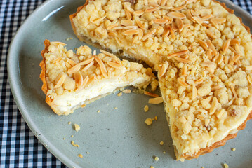 sliced homemade apple crumble cheese tart on ceramic plate
