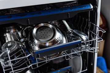 An open dishwasher with clean dishes in the kitchen.
