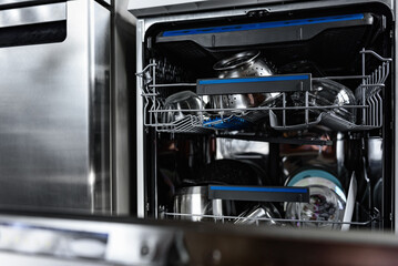 An open dishwasher with clean dishes in the kitchen.