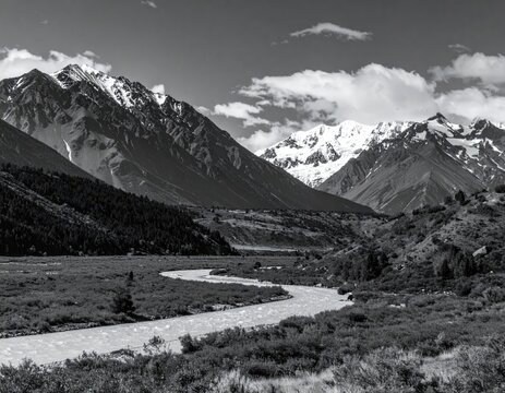 Snowy mountain range valley with river, black and white