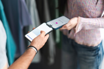 Two people are holding up their mobile phones, one showing a digital health pass, the other displaying a QR code for verification.