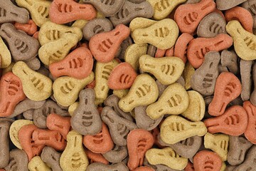 Dog biscuits background. Tasty dog ​​treats in three colors and flavors, viewed from above.