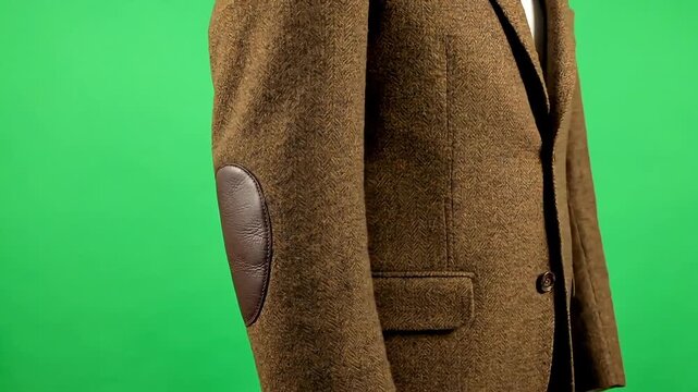 Man wearing a classic tweed jacket with leather elbow patches, ready for a stylish occasion