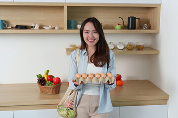 Sustainability. Happy woman holding eggs in eco-friendly kitchen.
