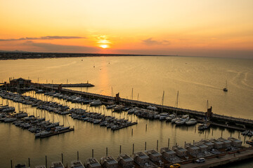 Obraz premium Italy yacht club top view. The sky in the evening. Water sea parking ships. Sunset sky at seaport of Italian city of Rimini in Summer. Sun horizon