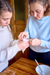 mother and a cranky toddler are cooking cream for a Christmas gingerbread house in the kitchen
