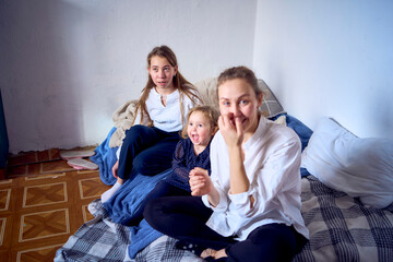 family with toddler and teenager playing games, laughing, clapping and celebrating a small family party