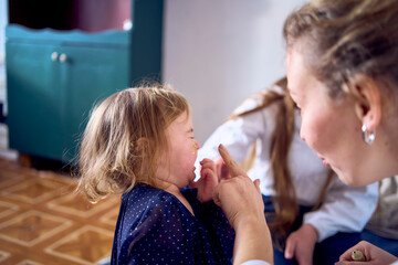 a family plays by painting each other's faces with gold glitter during a Christmas party at home