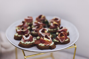 Beautifully decorated banquet catering table, with variety of with different food snacks appetizers on corporate birthday party event or wedding celebration, canape, salad, delicatessen setting