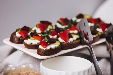 Beautifully decorated banquet catering table, with variety of with different food snacks appetizers on corporate birthday party event or wedding celebration, canape, salad, delicatessen setting