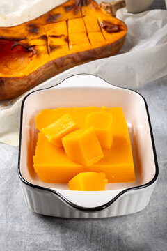 Pumpkin marmalade. Homemade pumpkin jelly candies on white plate on gray background.