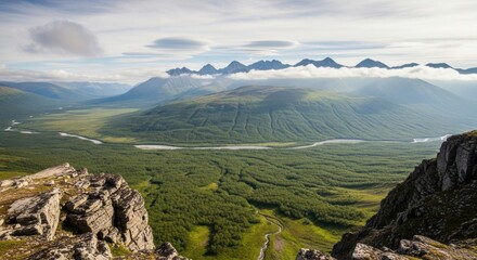 Majestic mountain range vista with lush green valley and rocky foreground