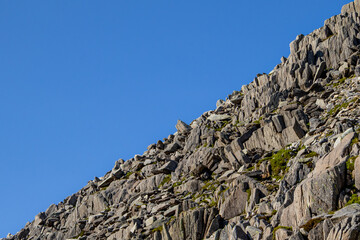 Jagged Rocky Slope Cutting Against a Bright Blue Sky