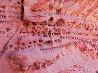 Desert landscape of the Red Tadrart with rock formations and golden sand under a blue sky. Natural scenery of the Algerian Sahara.