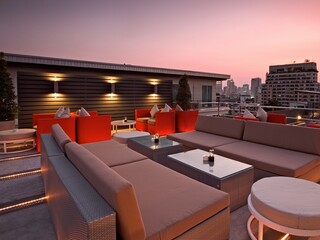 Luxury Rooftop Lounge at Sunset with City Skyline View