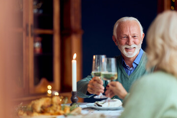 Elderly Couple Toaster With Wine During Cozy New Year Dinner Celebration With Candles