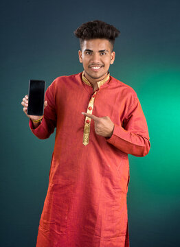 Young handsome traditional man showing a blank screen of a smartphone or mobile phone