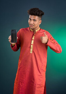 Young handsome traditional man showing a blank screen of a smartphone or mobile phone