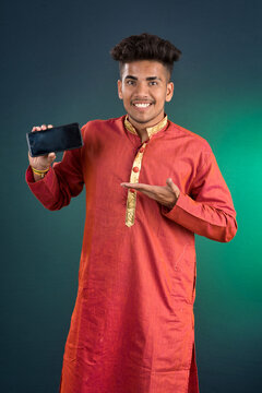 Young handsome traditional man showing a blank screen of a smartphone or mobile phone