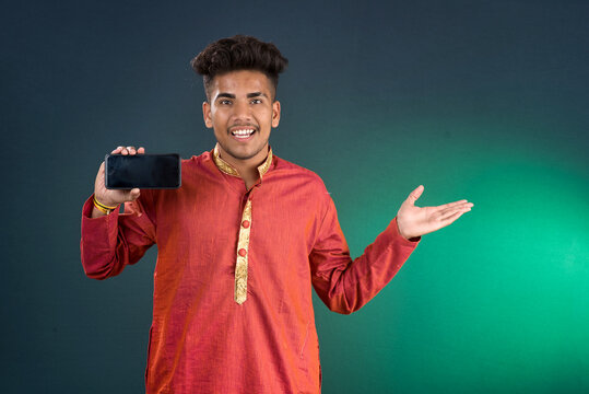 Young handsome traditional man showing a blank screen of a smartphone or mobile phone