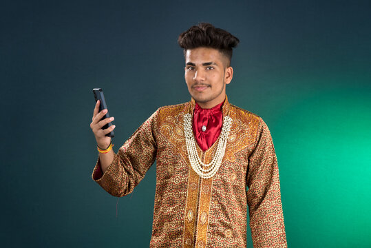 Young handsome man holding and using smartphone or mobile phone