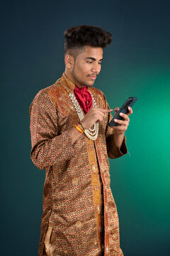 Young handsome man holding and using smartphone or mobile phone