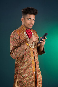 Young handsome man holding and using smartphone or mobile phone