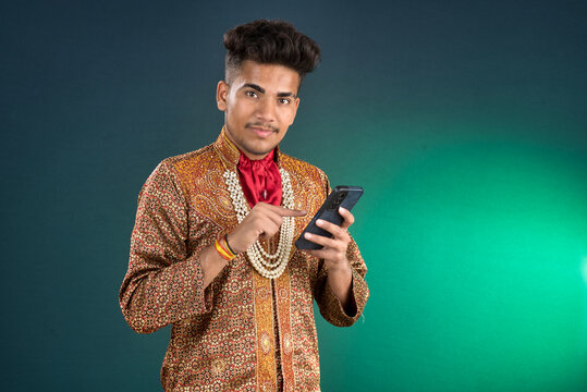 Young handsome man holding and using smartphone or mobile phone