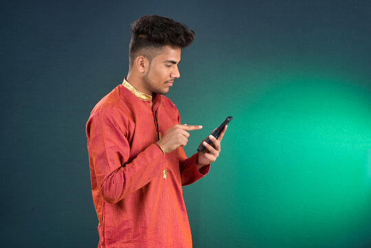 Young handsome man holding and using smartphone or mobile phone