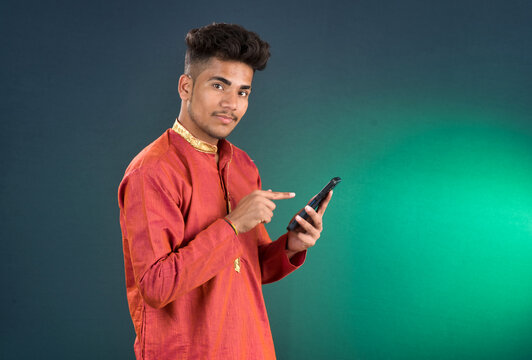 Young handsome man holding and using smartphone or mobile phone