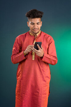 Young handsome man holding and using smartphone or mobile phone