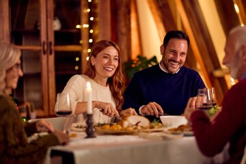 Warm Family Dinner Celebration With Wine Glasses And Candlelight During New Year Holiday Gathering