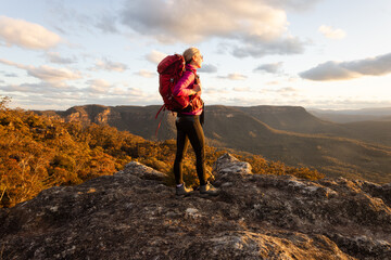 Hiker enjoying cliff top and valley views Blue Mountains