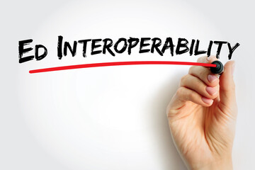 Ed Interoperability text handwritten by a hand underlined in red, illustrating educational system integration, data connection, and digital learning collaboration concept