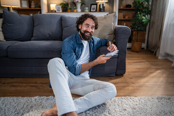 Fototapeta premium Man writing notes in notebook smiling at home